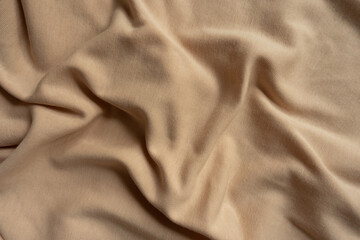 Simple beige cotton jersey fabric in soft folds