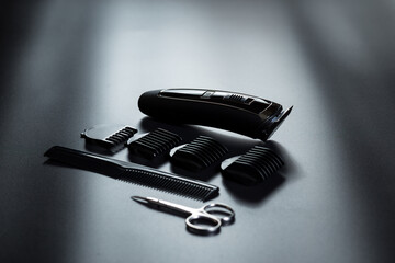 Electric shaving trimmer kit. Shaving machine on black. Barber tools on black with light on it.