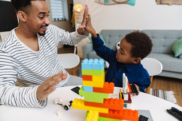 African american boy giving high five while playing with her father