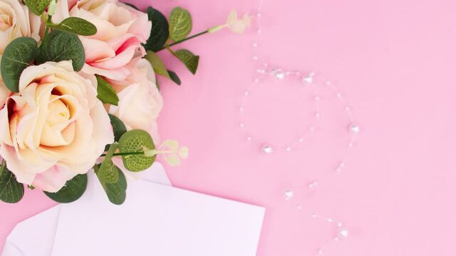 Paper in envelope appear with bouquet of roses on pastel pink theme. Stop motion