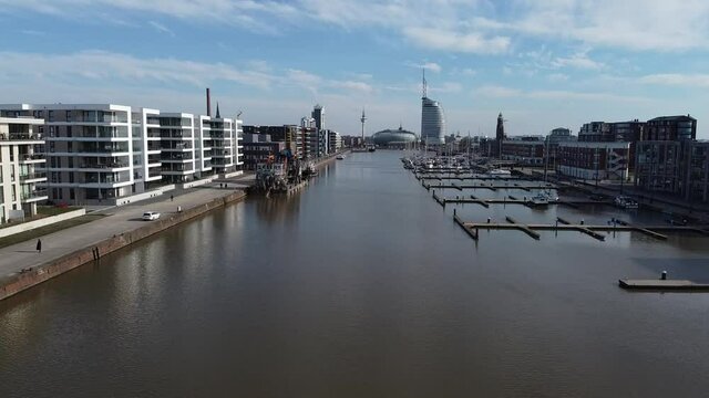 Mit der Drohne &uuml;ber der Wasseroberfl&auml;che vom Neuer Hafen in Bremerhaven mit Aussicht auf den Deich und die Weser, Aufstieg mit gutem Ausblick und Aussicht auf die Skyline
