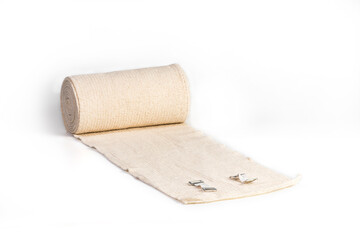 Woven elastic medical bandage rolled into roll and fixation clips on a white background with clipping path