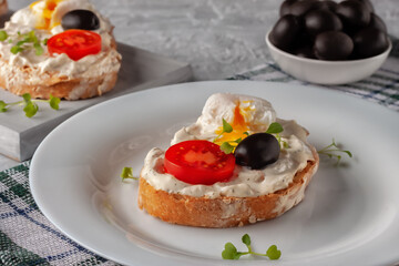 Bruschetta with tomato, olives and poached quail egg