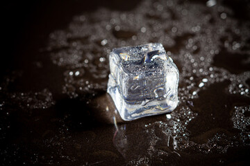 ice cubes reflection on black table background.