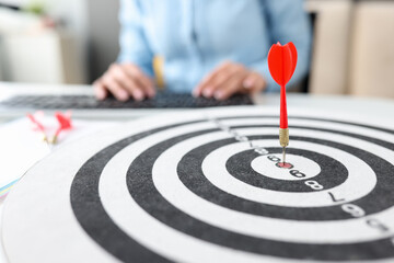 Red dart target arrow hitting on bullseye closeup