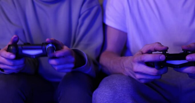 couple playing console video games together. neon lights. slider shot