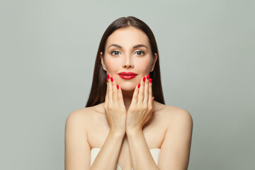 Cute young woman showing red manicured nails on hands. Body care and manicure concept