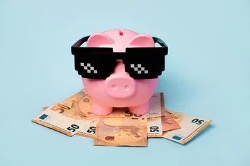 Fotobehang Pink piggy money bank with black sunglasses and euro bills © esthermm