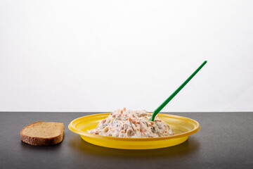 Salad in disposable dishes on a black table with a piece of black bread