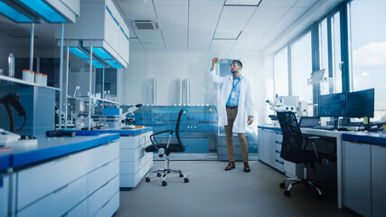 Modern Medical Research Laboratory with Male Scientist Analysing Microbiological Sample, Using Microscope. Advanced Scientific Lab for Drugs, Vaccine Development, Full of High-Tech Equipment
