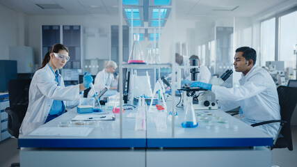 Modern Medical Research Laboratory: Diverse Team of Scientists Working with Pipette, Analysing...
