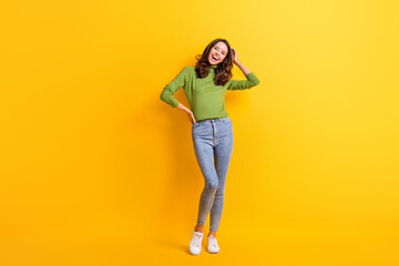 Full size photo of pretty charming young woman touch hair hold hand waist isolated on vivid yellow color background