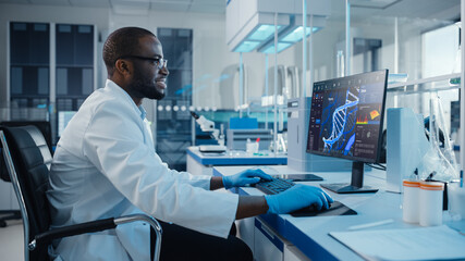 Modern Medical Laboratory: Male Scientist, Typing on Keyboard working on Computer, Scren Shows DNA...