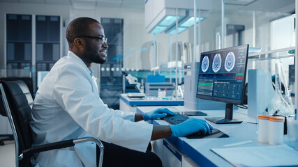 Modern Medical Laboratory: Male Scientist, Typing on Keyboard, Working on Computer, Scren Shows MRI Brain Scans. Advanced Scientific Lab, Medicine Technology Development. - obrazy, fototapety, plakaty