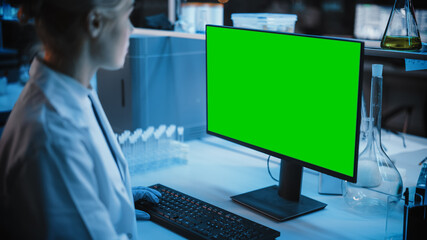 Medical Research Laboratory: Portrait of Female Scientist Working on Computer with Green Chroma Key Screen. Advanced Scientific Lab for Medicine, Biotechnology, Vaccine Development. Dark Blue Shot