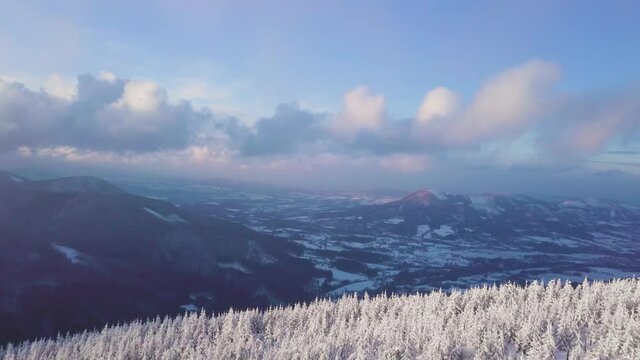 Celadna in the distance, flying above frozen trees towards the clouds in Beskydy mountains, UHD or 4k, 30fps