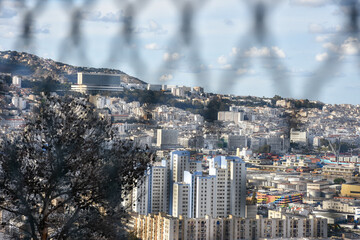 a beautiful aerial panoramic view of Algiers city behind a fence 