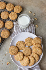 Healthy oatmeal cookies with cereals, seeds and nuts with a cup of milk on concrete background. Diet vegan cookies. Top view.