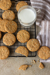 Healthy oatmeal cookies with cereals, seeds and nuts with a cup of milk on concrete background. Diet vegan cookies. Top view.