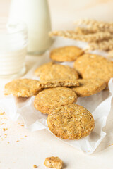 Healthy oatmeal or multigrain cookies with seeds and nuts on baking paper, light concrete background.