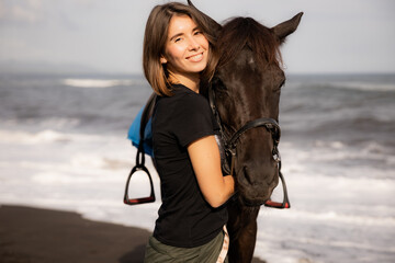 Obraz premium Portrait of happy woman and brown horse. Young Caucasian woman hugging horse. Romantic concept. Love to animals. Nature concept. Bali