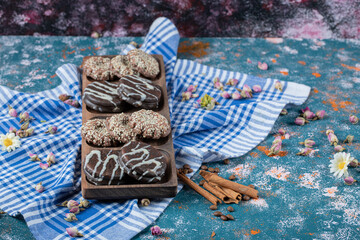 Chocolate and coconut cookies on a wooden board served with a cup of tea