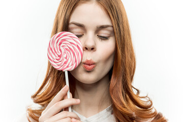 pretty red-haired woman with circle of lollipop in her hands charm passion sweets