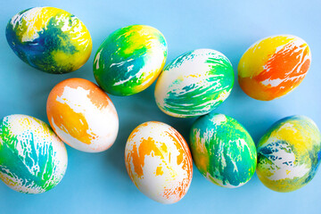 Top view of multicolored Easter eggs on a blue background. Happy Easter card. Dyed Easter eggs. Copy space for your text. Flat lay style. Top view. 