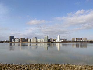 Fototapeta premium Greenwich Peninsular Thames path shoreline view of riverside homes with beautiful reflections in the water
