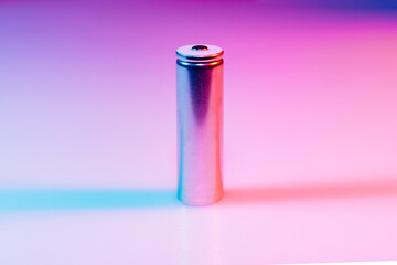 AA silver battery on illuminated by multicolored light. 