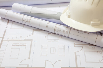 Construction concept. Residential building drawings and hardhat on an office desk
