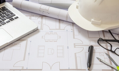 Construction concept. Residential building drawings and hardhat on an office desk