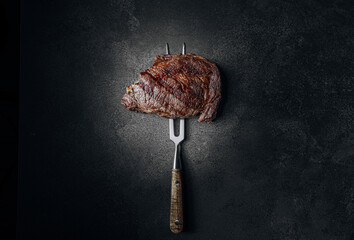 grilled beef steak on a dark background. expensive marbled beef of the highest grade fried to rare on the grill - obrazy, fototapety, plakaty