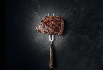 Foto op Canvas grilled beef steak on a dark background. expensive marbled beef of the highest grade fried to rare on the grill © Mikhaylovskiy 