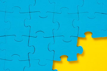 Unfinished blue puzzle at the yellow corner