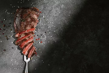 Gartenposter grilled beef steak on a dark background. expensive marbled beef of the highest grade fried to rare on the grill © Mikhaylovskiy 