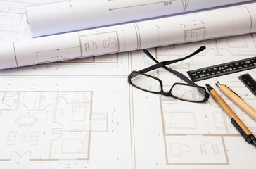 Residential building drawings and pencils on an office desk. Construction concept.