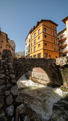 Escaldes Andorra, Roman arched stone bridge over the river between city buildings