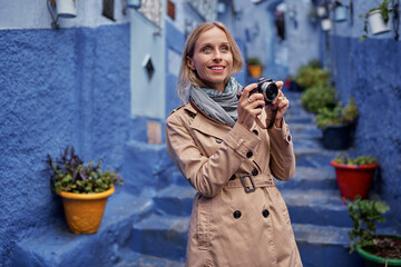 Traveling by Morocco. Young woman walking in medina of blue city Chefchaouen.