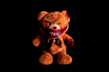 scary bear with a creepy bloody grin on a black background. horror toy. halloween concept. a...