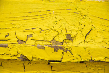 Background from old yellow boards. Close-up of cracks and chips in paint.