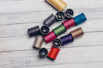 sewing accessories colored threads top view wooden background