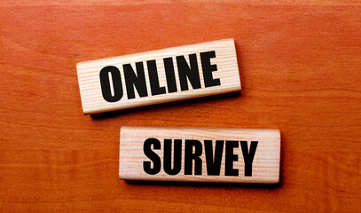 On a wooden table are two wooden blocks with the text question ONLINE SURVEY
