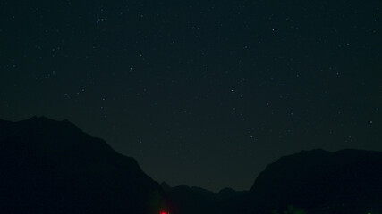 Fototapeta premium Time lapse of Night landscape with mountains and stars.