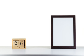 Wooden calendar 26 may with frame for photo on white table and background