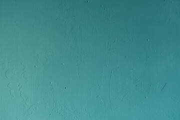 Just a plastered wall, textured, with scratches, pits, cracks, painted in light green.