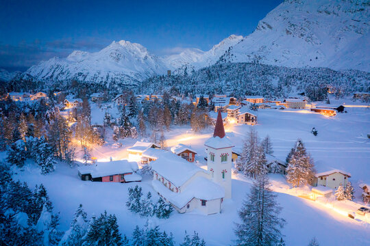 Dusk over Chiesa Bianca and Maloja village covered with snow, Bregaglia, Engadine, Graubunden Canton, Switzerland, Europe