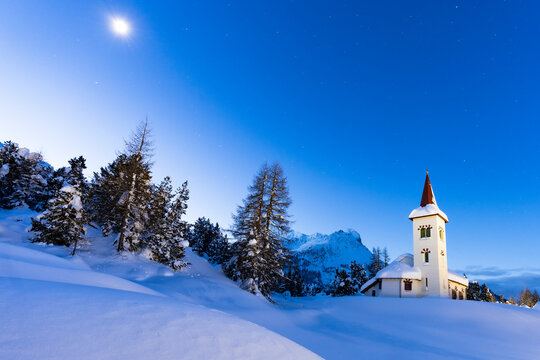 Dusk over Chiesa Bianca in the snowy landscape lit by moon, Maloja, Bregaglia Valley, Engadine, Graubunden Canton, Switzerland, Europe