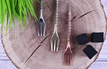 decorative forks on a wooden frame with green grass and coconut charcoal