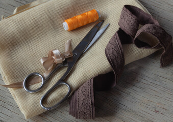 orange thread, braid, fabric and scissors for needlework, sewing, crafts